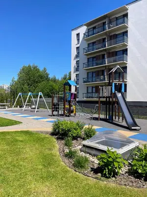 a playground in a park next to a building at Family room in Vilnius