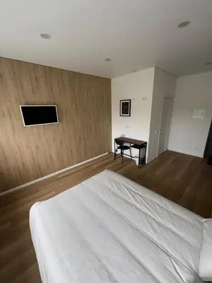a bedroom with a white bed and a desk at 9 New Airport Apartment in VNO