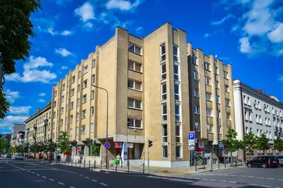 a tall building on a city street with a blue sky at Small Studio Apartment in Kaunas