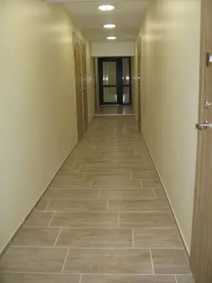 a hallway of an office building with a tile floor at Tiny Studio Apartment in Kaunas