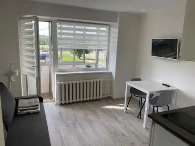 a living room with a table and a window at Vilnius Apartment with Balcony in Vilnius