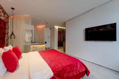 a bedroom with a red and white bed and a television at SPA apartments in city centre in Vilnius