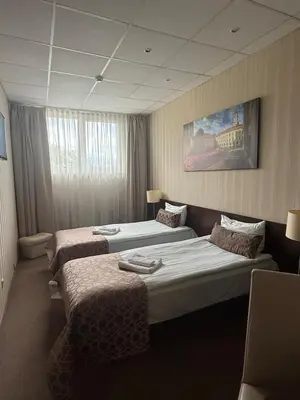 a hotel room with two beds and a painting on the wall at Naujamiescio Studio 307 in Vilnius