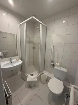 a white bathroom with a shower and a toilet at Naujamiescio Studio 307 in Vilnius