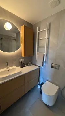 a bathroom with a sink and a toilet and a mirror at Algirdo Sunlight Studio in Vilnius