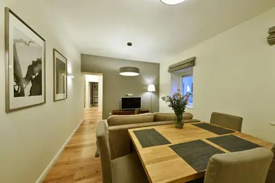 a living room with a dining room table and a couch at Domillion 3bdr 2baths President Palace park L419A in Vilnius