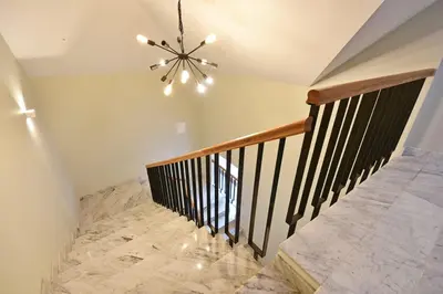 a staircase with a chandelier and marble flooring at Domillion New modern Vilnius old town studio U2302 in Vilnius