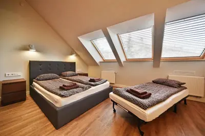 two beds in a room with two windows at Domillion New modern Vilnius old town studio U2302 in Vilnius