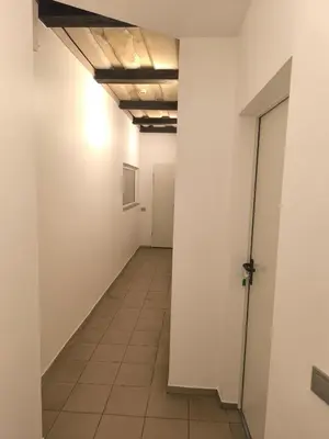 an empty hallway with white walls and a tile floor at Studio3 in Utena
