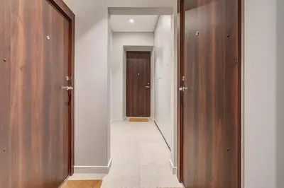a hallway with two wooden doors and a hallway leading to a door at Domillion Studio Modern Old Town Retreat So1b in Vilnius