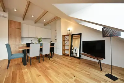 a dining room with a table with chairs and a television at Domillion Pylimo Penthouse duplex apt 15ppl P36D in Vilnius