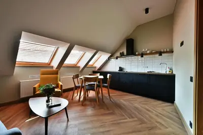 a kitchen and a living room with a table and chairs at Domillion New Modern Old town apt 16 ppl U2C1 in Vilnius