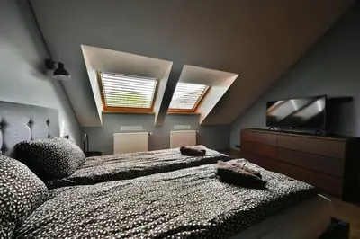 a bedroom with a large bed and a flat screen tv at Domillion New Modern Old town apt 16 ppl U2C1 in Vilnius