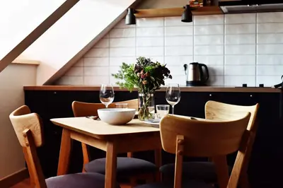 a table with a vase of flowers and wine glasses at Domillion New Modern Old town apt 14 ppl U2C2 in Vilnius