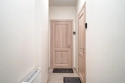 a hallway with a wooden door and a floor at Zemaitijos Versatile 12ppl Triplex in Vilnius