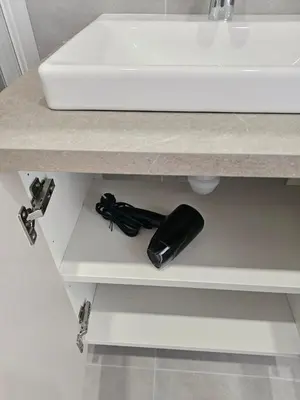 a bathroom counter with a sink and a black phone at Cozy Apartment for Rest & Creativity 6 in Vilnius