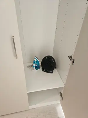 a white cabinet with a helmet sitting on a shelf at Šopeno Butas Cozy Quiet and Well-Located 5 in Vilnius
