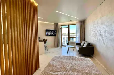 a room with a bed and a couch and a television at New luxury modern Apartment in Šnipiškės in Vilnius