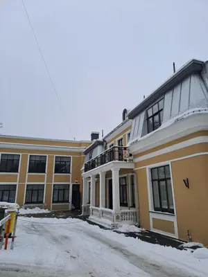 a large yellow building with a balcony in the snow at Italian Embassy Suites 3 in Kaunas