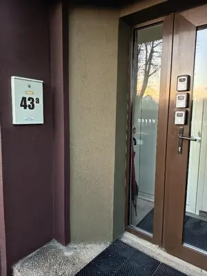 a sign on the side of a building next to a door at XXL apartamentai su nemokamu parkingu in Šiauliai