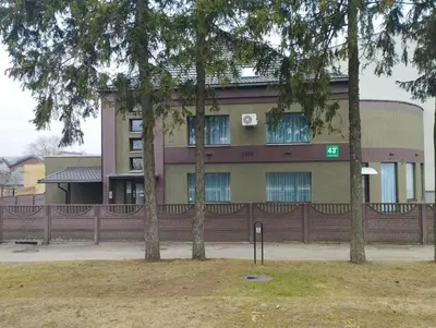 a building with trees in front of it at L apartamentai su nemokamu parkingu in Šiauliai