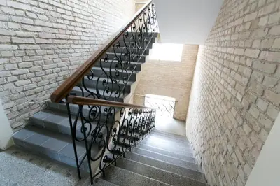 a staircase with a metal railing next to a brick wall at G-45 in Vilnius