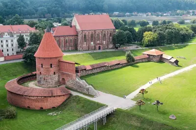 an aerial view of a large brick building in a park at Owl Apartments in Kaunas