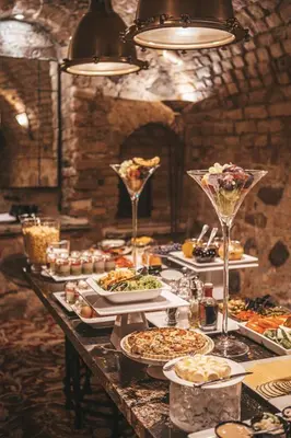 a long table with plates of food and wine glasses at Hotel Apia in Vilnius