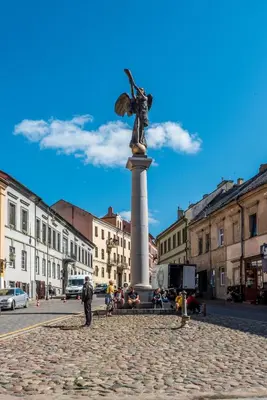 a statue of a woman on a pillar in a city at Angel House Vilnius 40 in Vilnius