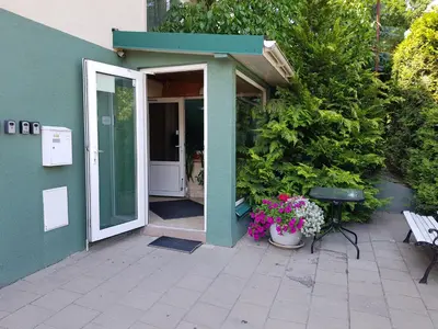 an open door of a house with flowers and a bench at Cozy Garden Free parking in Vilnius