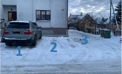 a car parked in a parking lot in the snow at Sauliaus apartamentai in Panevėžys