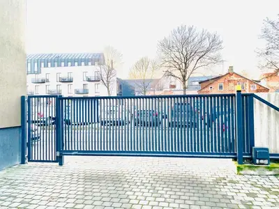 a blue metal gate in front of a building at Modern 1BD Apartment in Old Town by Hostlovers in Kaunas
