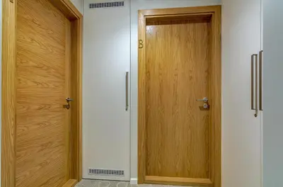 a corridor with two wooden doors in a room at City Studio 1B in a great location in Vilnius