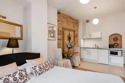 a living room with a bed and a kitchen at Vilnius Apartments in Vilnius