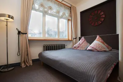 a bedroom with a bed with a window and a clock at Town Hall Apartments in Vilnius