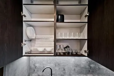 a kitchen cabinet with plates and glasses on it at City Center Loft in Kaunas
