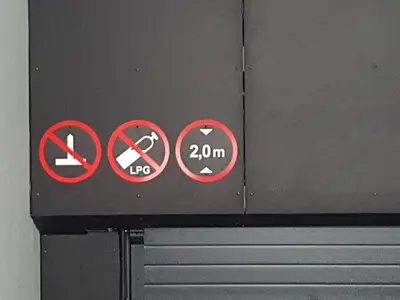 a sign on a wall withhibited signs on it at HaPPy Inn Emporia, Self chek-in, Parking in the underground garage in Vilnius