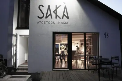 a restaurant with a sign on the side of a building at SAKÀ Vacation House in Druskininkai