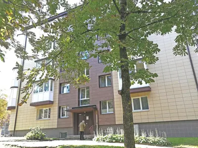 a man standing in front of a building at Šiauliai Central Spot Apartment - Draugystes pr. in Šiauliai