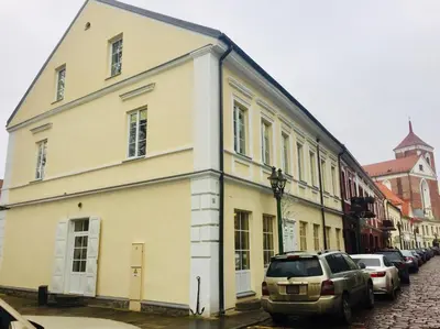 a white building on a street with parked cars at Kaunas Castle Apartments - Studio in Kaunas