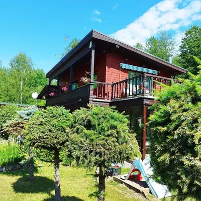 a wooden house with a balcony and a porch at Viešnagė pas Valentiną in Sužionys