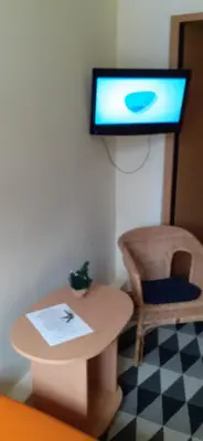 a room with a table and a tv on a wall at Attic rooms at Laisves avenue in Kaunas