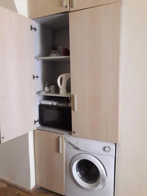 a kitchen with a washing machine and a microwave at Attic rooms at Laisves avenue in Kaunas