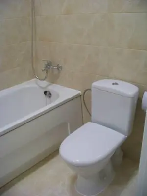 a bathroom with a white toilet and a bath tub at Near PANORAMA apartment Self check-in Garage free in Vilnius