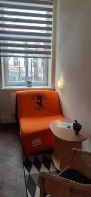 an orange bed in a room with a window at Small room with a private external bathroom in Kaunas