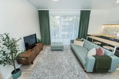 a living room with a blue couch and a tv at Cozy Piliamiesčio apartament No 1 by URBAN RENT in Kaunas