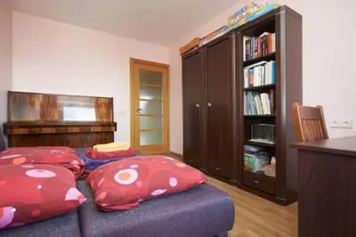 a living room with two red pillows on a couch at Cozy private room in a three room apartment Free parking Feel like at home in Vilnius