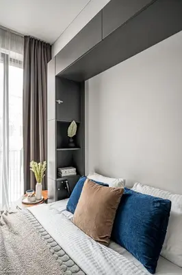 a bedroom with a large bed with blue pillows at Vilnius Old Town Studio Renessaince 5 in Vilnius