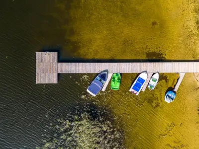 a group of boats parked next to a dock at Paplūdimio namukas in Molėtai