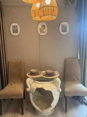 a table with two chairs and a table with plates on it at Vila Forest Resort in Kvietkučiai